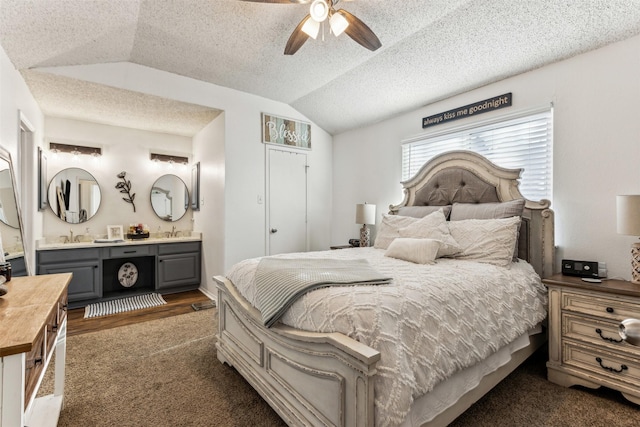 bedroom with ceiling fan, sink, ensuite bathroom, and vaulted ceiling