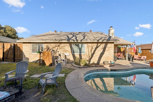 back of house with a fenced in pool and a patio