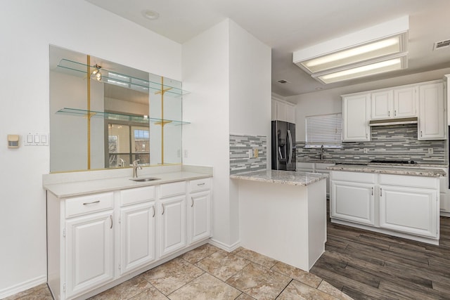 kitchen featuring white cabinetry, black appliances, and tasteful backsplash