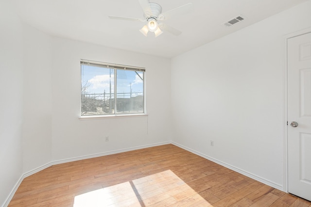 empty room with ceiling fan and light hardwood / wood-style flooring