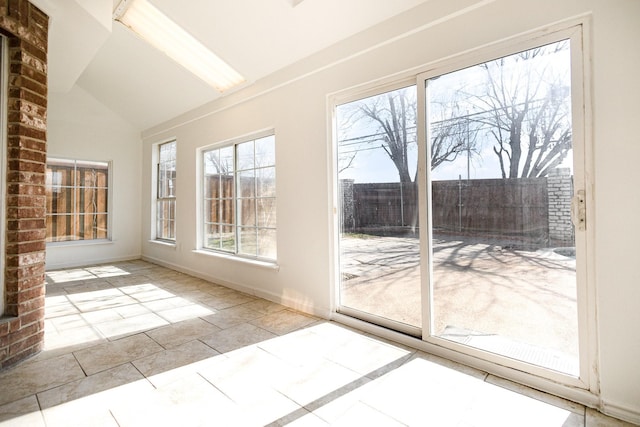 unfurnished sunroom featuring vaulted ceiling