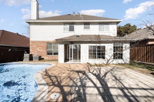 rear view of house with central AC unit and a patio