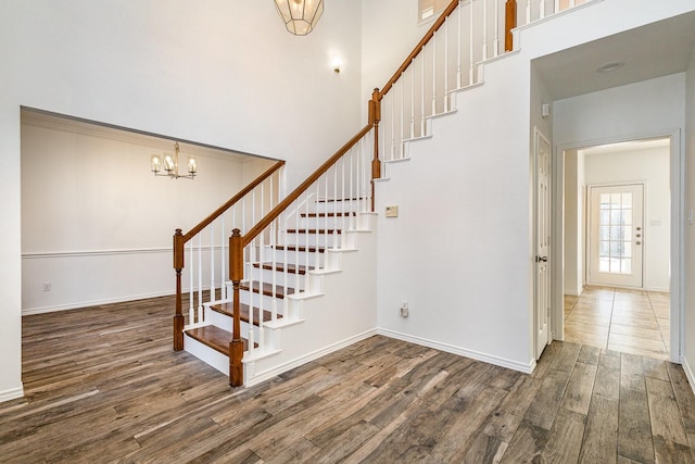 stairs with an inviting chandelier and hardwood / wood-style flooring