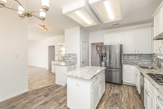 kitchen featuring white cabinetry, sink, stainless steel appliances, and a center island