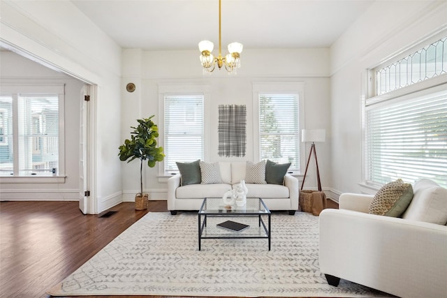 living room with an inviting chandelier, dark hardwood / wood-style flooring, and a wealth of natural light