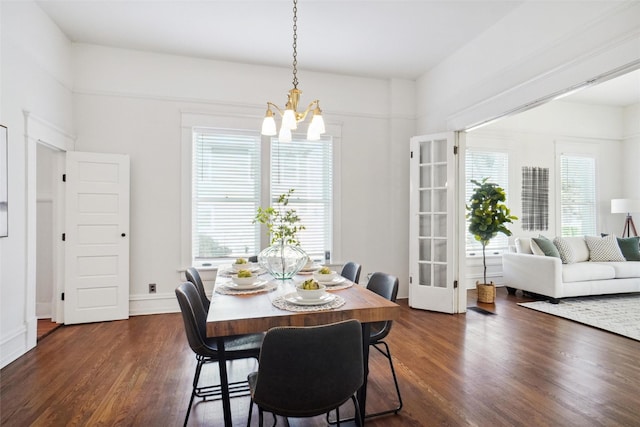 dining area featuring dark wood-type flooring and a chandelier