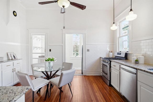 kitchen featuring white cabinetry, appliances with stainless steel finishes, and decorative light fixtures