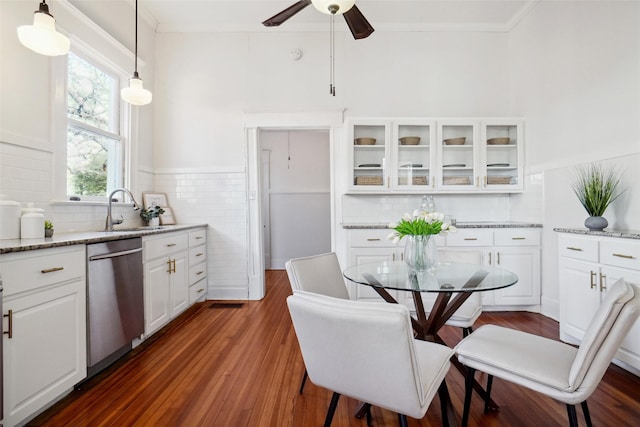 kitchen featuring sink, white cabinetry, light stone counters, dishwasher, and pendant lighting