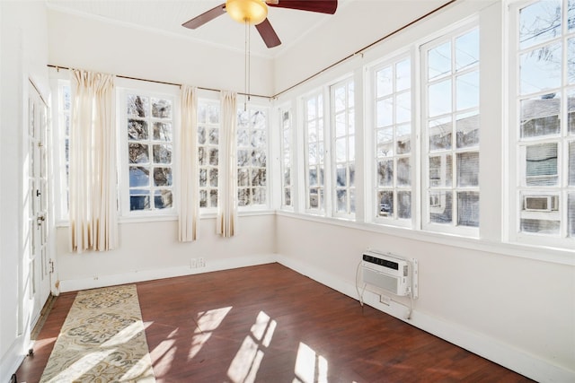 unfurnished sunroom featuring ceiling fan and a wall mounted AC