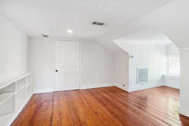 additional living space featuring wood-type flooring and vaulted ceiling