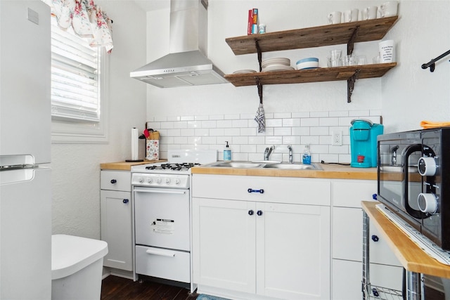 kitchen featuring range hood, tasteful backsplash, butcher block counters, white cabinets, and white appliances