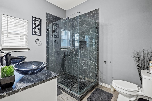 bathroom featuring toilet, a shower with door, and tile patterned flooring