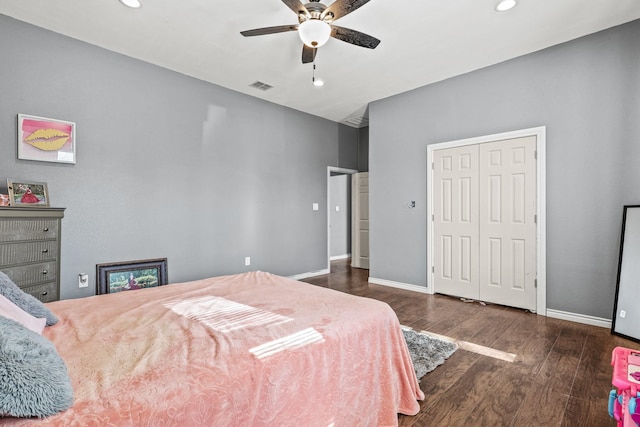 bedroom with dark wood-type flooring, ceiling fan, and a closet