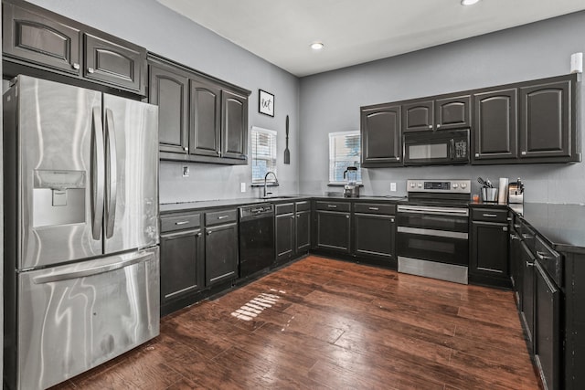 kitchen featuring black appliances, dark hardwood / wood-style flooring, and sink