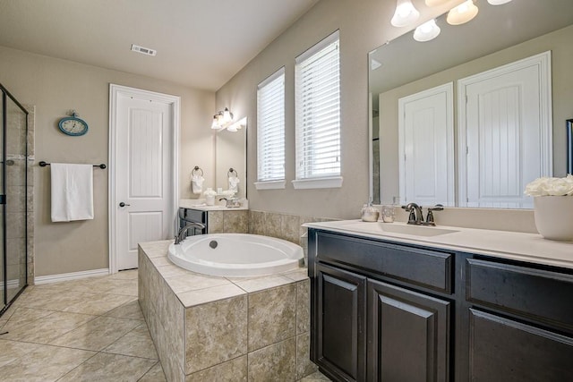 bathroom with vanity, tile patterned floors, and tiled tub