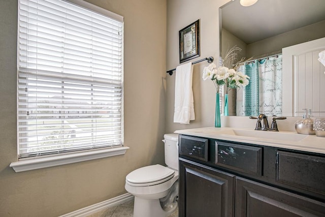 bathroom with toilet, vanity, and tile patterned flooring