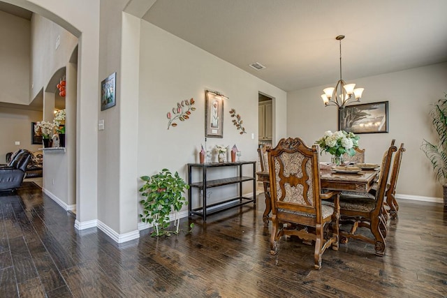 dining space with dark wood-type flooring and a chandelier