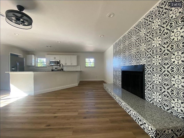 unfurnished living room featuring sink and dark hardwood / wood-style floors