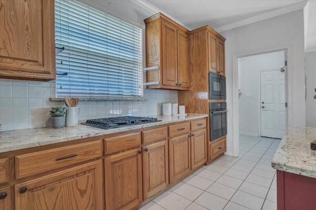 kitchen featuring tasteful backsplash, black appliances, light stone countertops, ornamental molding, and light tile patterned floors