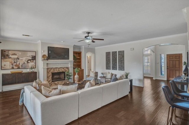 living room with ceiling fan, ornamental molding, a fireplace, and dark hardwood / wood-style flooring