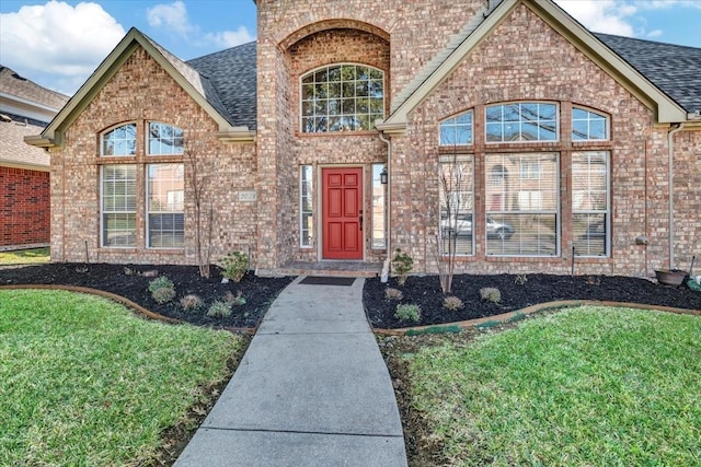 entrance to property featuring a lawn