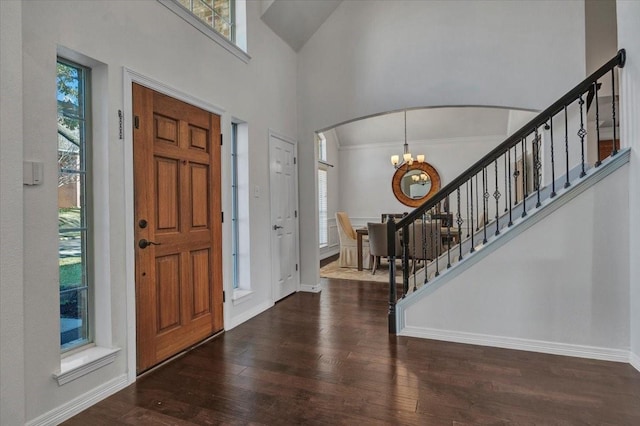 entrance foyer with dark hardwood / wood-style flooring, a healthy amount of sunlight, and a notable chandelier