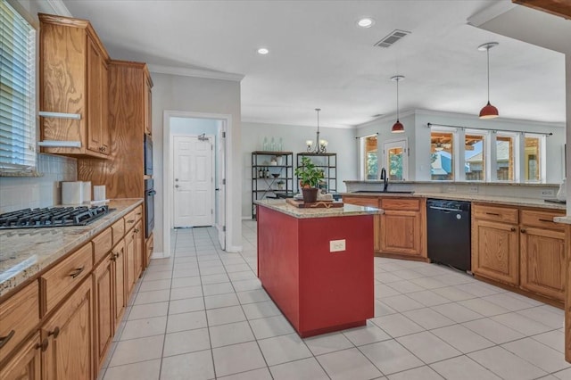 kitchen with pendant lighting, black appliances, a kitchen island, ornamental molding, and light stone counters