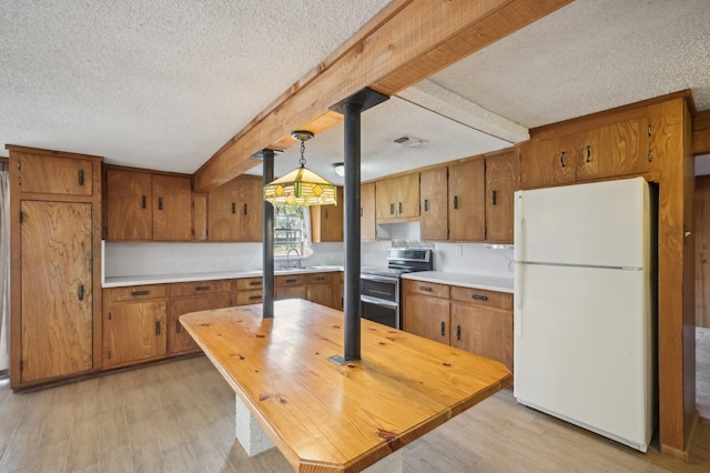 kitchen with white fridge, light wood-type flooring, double oven range, and hanging light fixtures