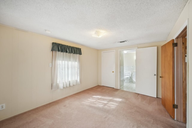 carpeted spare room with a textured ceiling