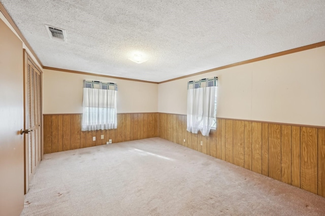 carpeted spare room with a textured ceiling and ornamental molding