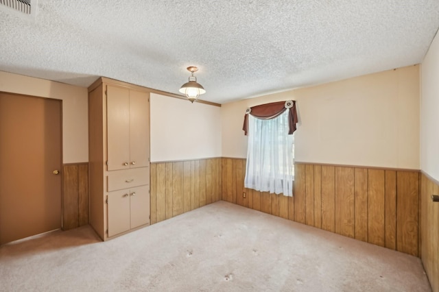 carpeted spare room with a textured ceiling