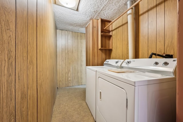 laundry area with washer and dryer and wood walls