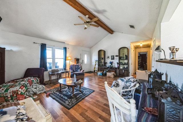 living room featuring ceiling fan, wood-type flooring, a textured ceiling, and vaulted ceiling with beams