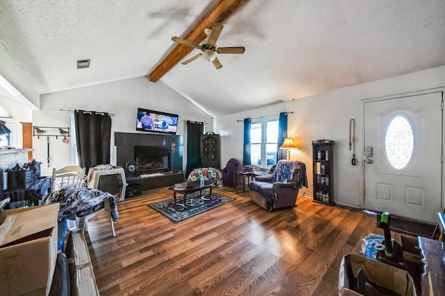 living room with ceiling fan, vaulted ceiling with beams, a textured ceiling, and hardwood / wood-style flooring