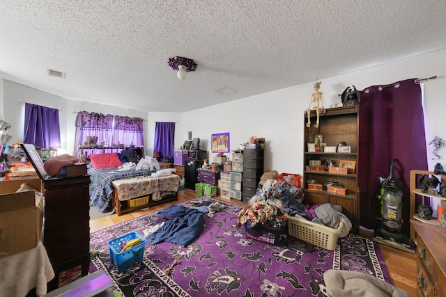 bedroom featuring a textured ceiling and hardwood / wood-style floors