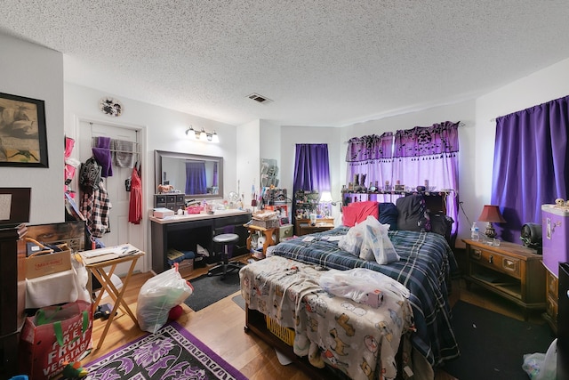 bedroom featuring a closet, a textured ceiling, and hardwood / wood-style flooring