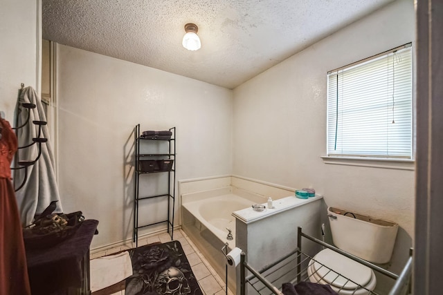 bathroom with tile patterned floors, a bathtub, and a textured ceiling