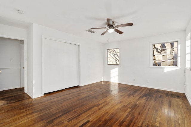 unfurnished bedroom with ceiling fan, dark hardwood / wood-style flooring, and a closet