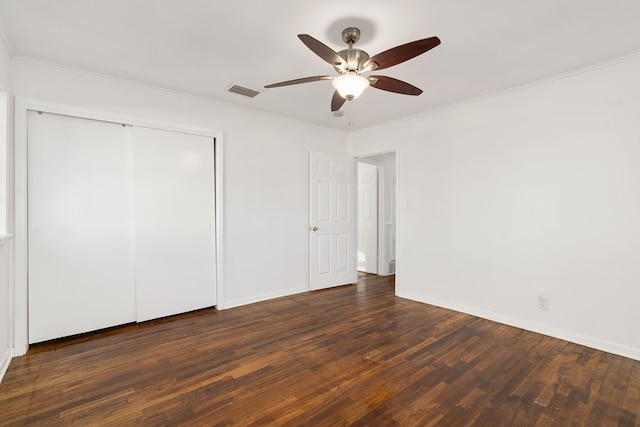 unfurnished bedroom featuring ceiling fan, dark hardwood / wood-style flooring, a closet, and crown molding