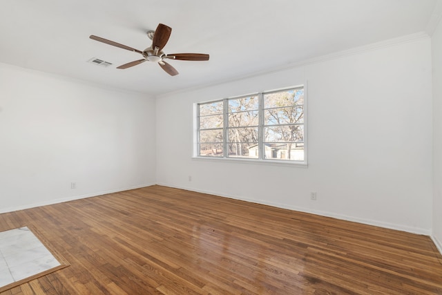 empty room featuring hardwood / wood-style flooring, crown molding, and ceiling fan