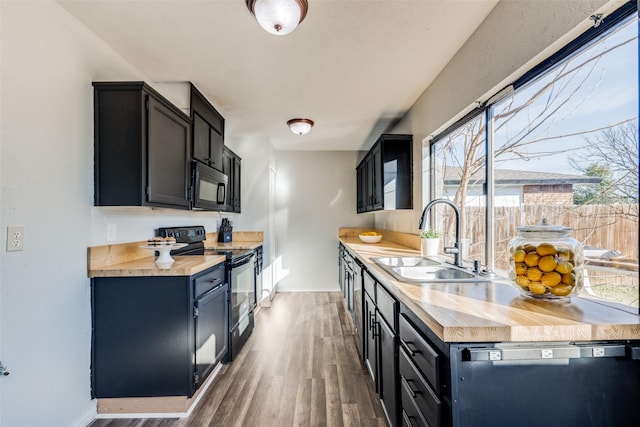 kitchen with black appliances, dark hardwood / wood-style flooring, and sink