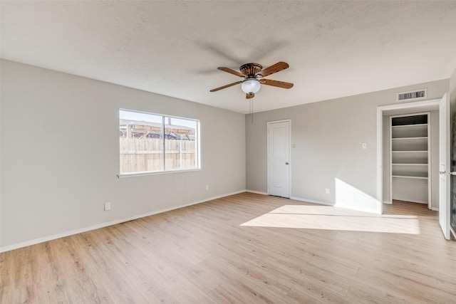 unfurnished bedroom featuring ceiling fan, a textured ceiling, and light hardwood / wood-style floors