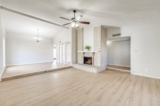 unfurnished living room featuring light hardwood / wood-style floors, a fireplace, a textured ceiling, ceiling fan with notable chandelier, and lofted ceiling with beams