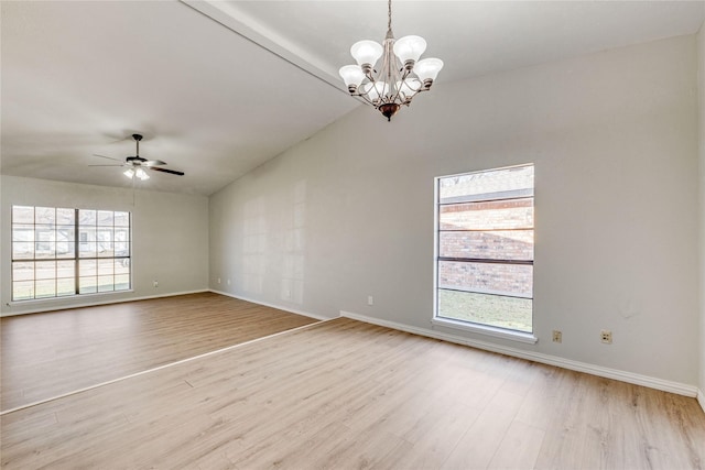 spare room featuring vaulted ceiling, a healthy amount of sunlight, ceiling fan with notable chandelier, and light hardwood / wood-style flooring