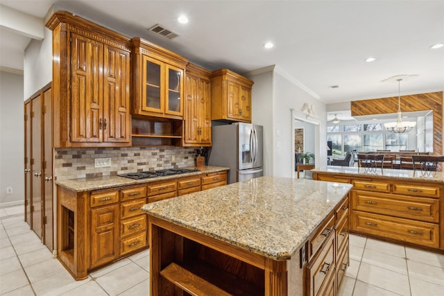 kitchen featuring appliances with stainless steel finishes, a center island, decorative light fixtures, a chandelier, and light tile patterned floors