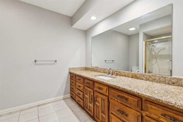 bathroom featuring toilet, vanity, tile patterned floors, and a shower with shower door