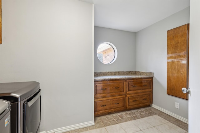 laundry area featuring washing machine and dryer and light tile patterned floors