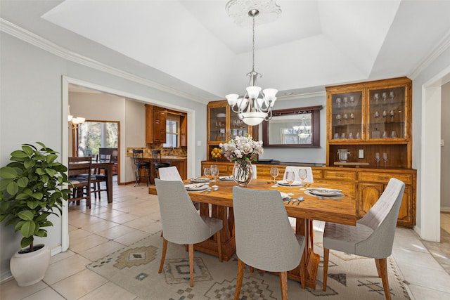 tiled dining space featuring an inviting chandelier, ornamental molding, and a tray ceiling