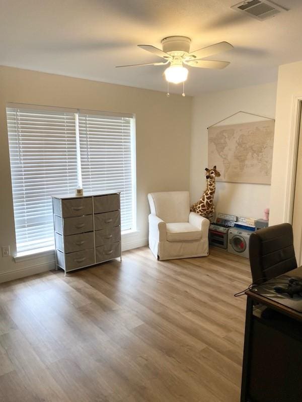 sitting room featuring light hardwood / wood-style floors and ceiling fan