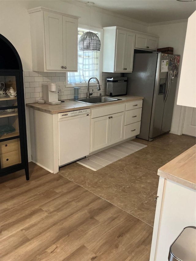 kitchen with sink, white cabinetry, decorative light fixtures, stainless steel fridge with ice dispenser, and white dishwasher